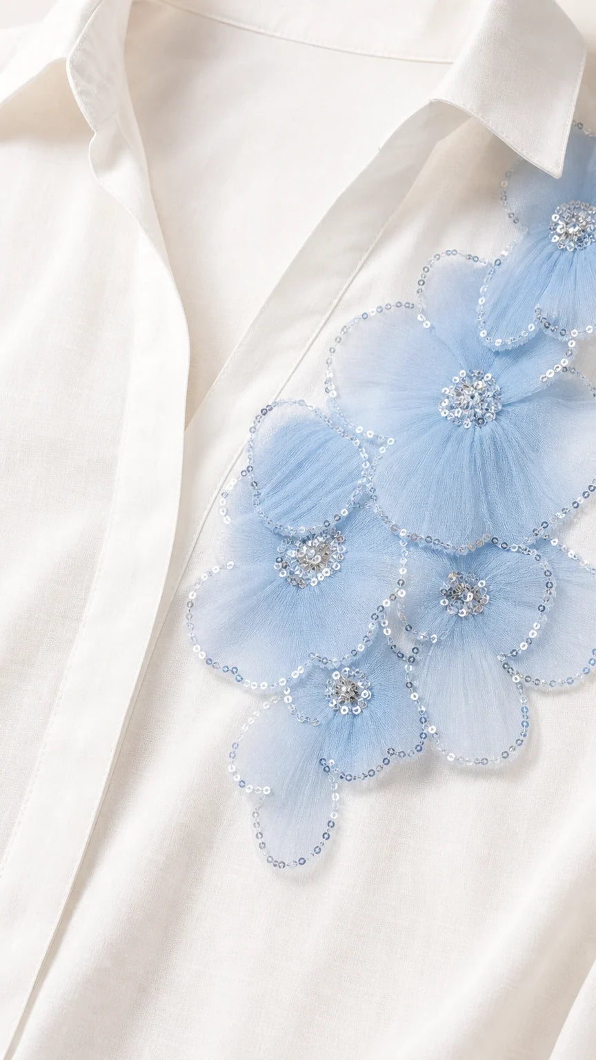 Close-up detail of light blue 3D mesh floral appliqué with sequin and bead embellishments