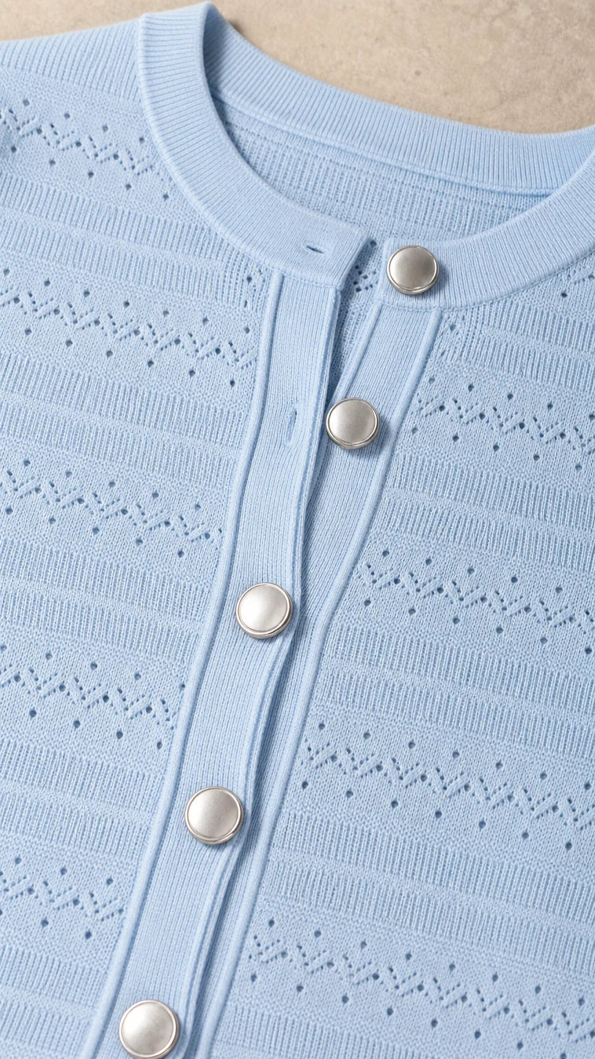 Close-up detail of knit texture and button placket on light blue dress