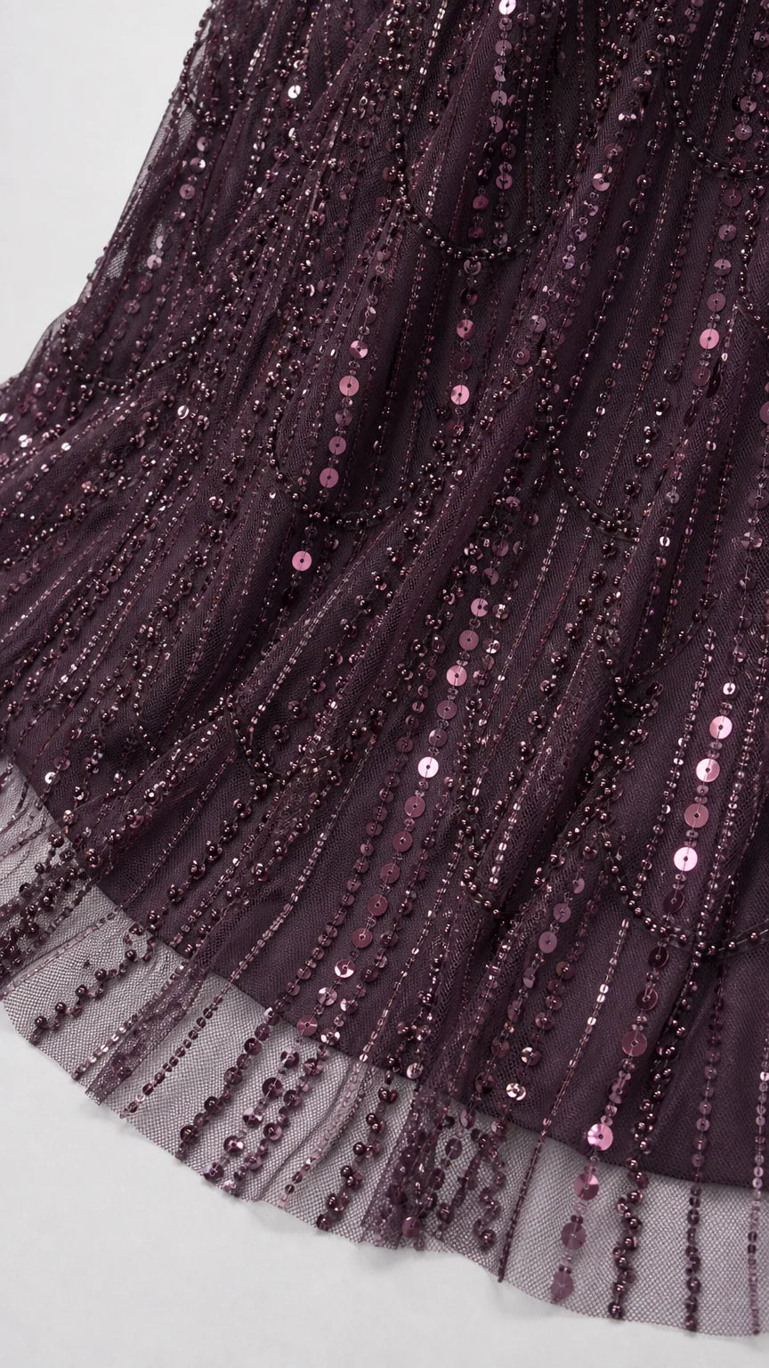 Close-up detail of sheer mesh hem with vertical plum sequin and bead embellishments