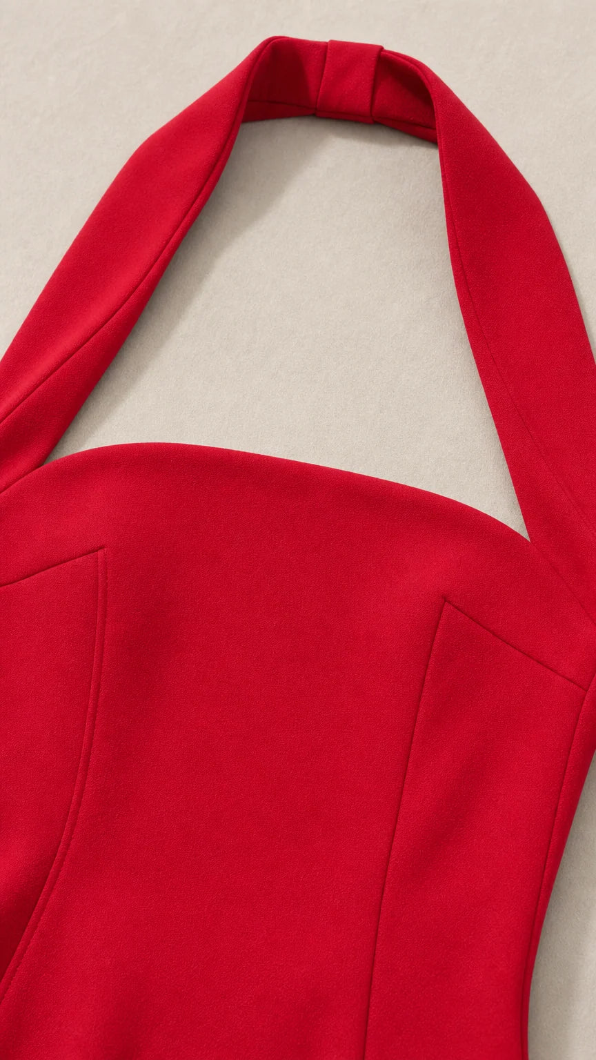Close-up detail of red halter neck strap and bodice
