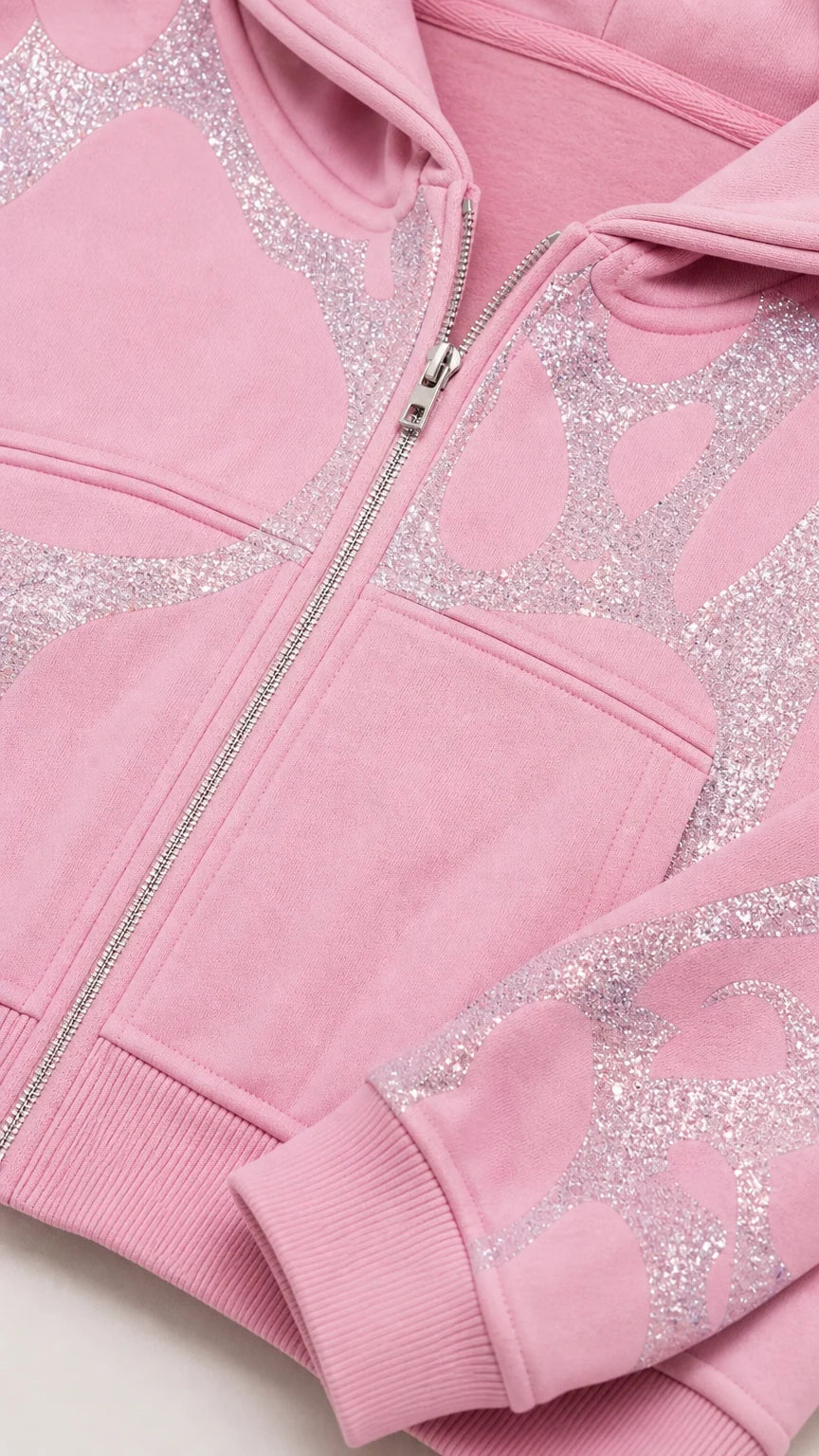 Close-up detail of Light Pink cropped zip hoodie showing glitter graphic and zipper hardware