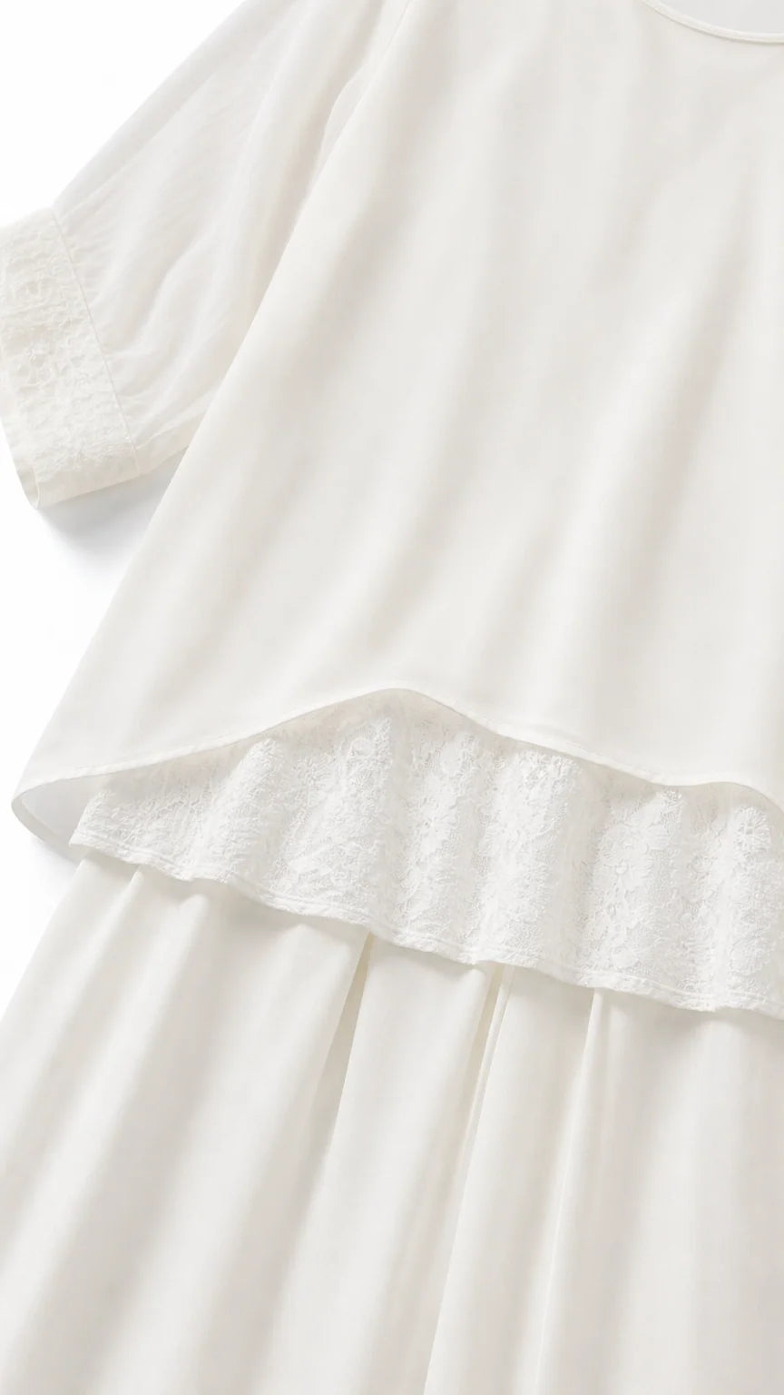 Close-up of white tunic hem with delicate lace trim