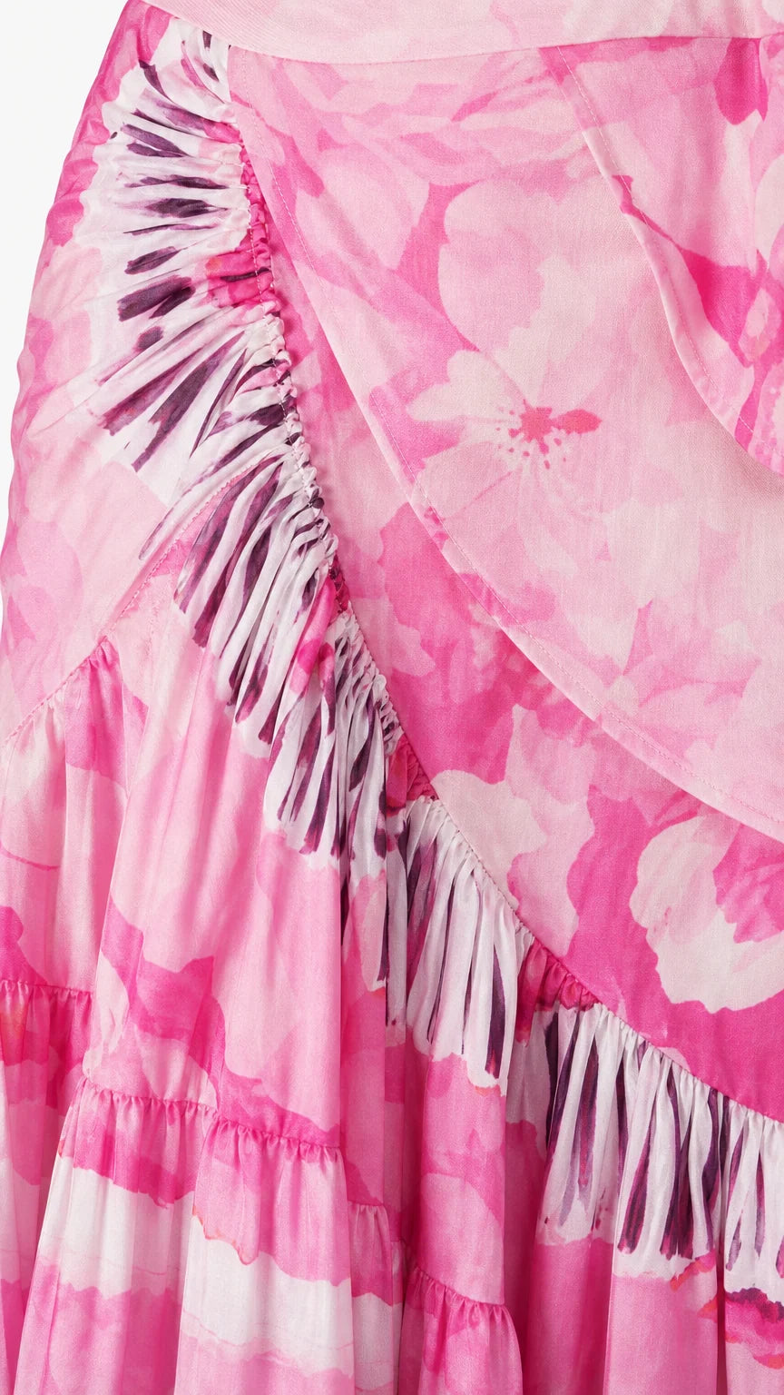 Close-up detail of fabric, ruffles, and tassel trim on pink wrap skirt