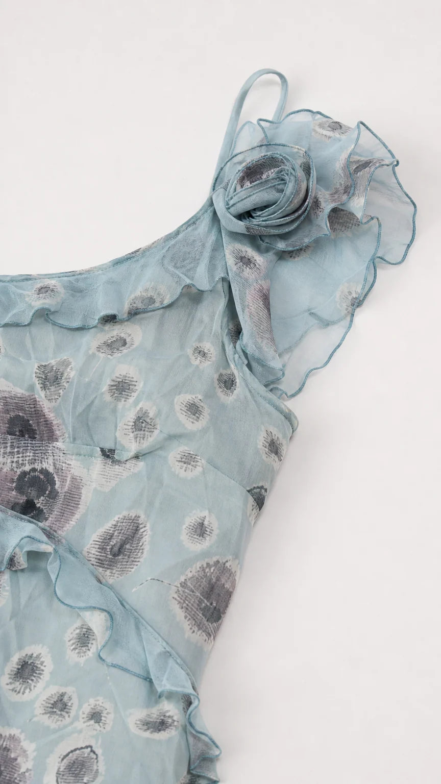 Close-up detail of 3D rosette and ruffle trim on dusty blue floral fabric