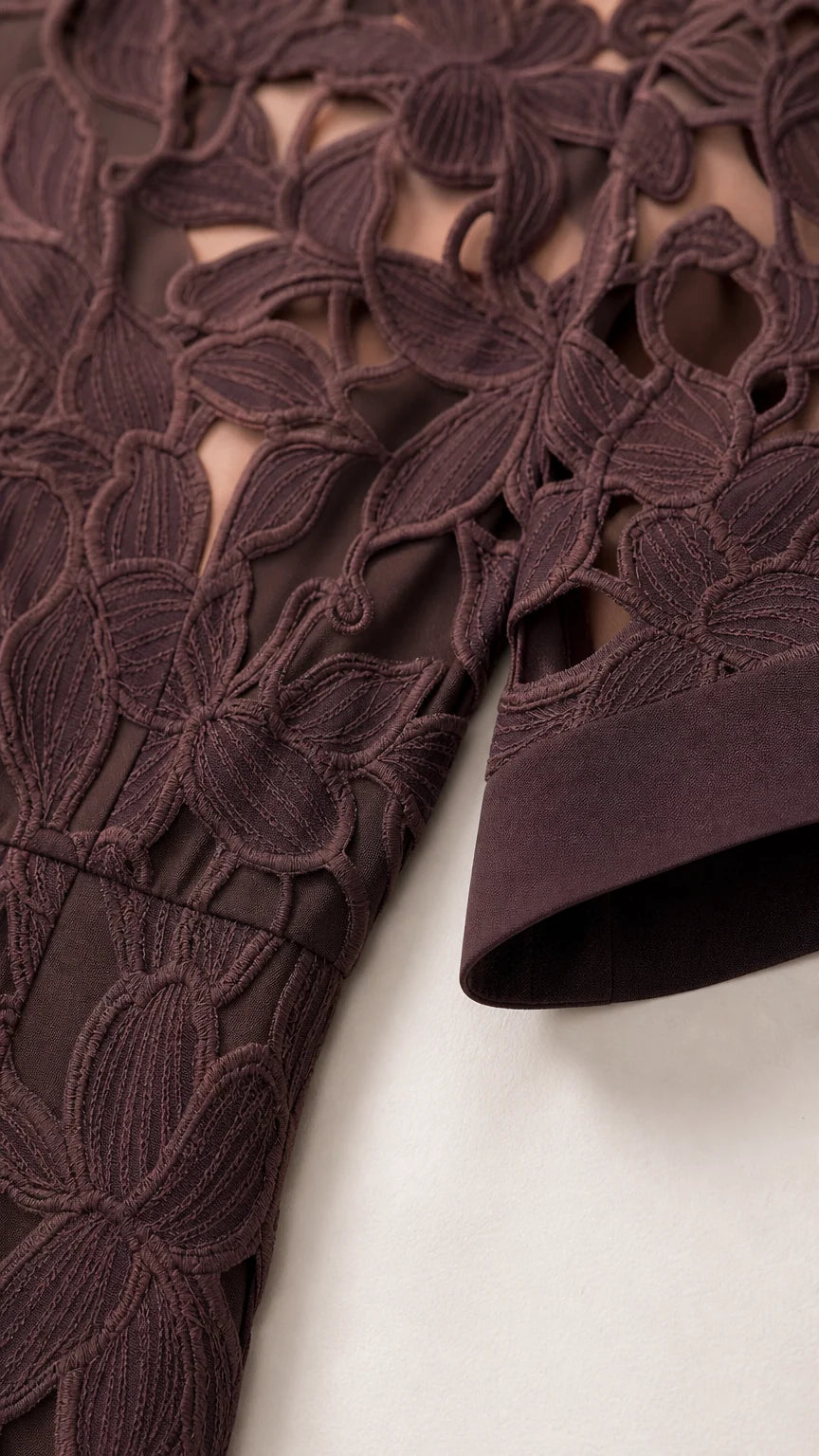 Close-up detail of textured floral lace embroidery and sleeve cuff