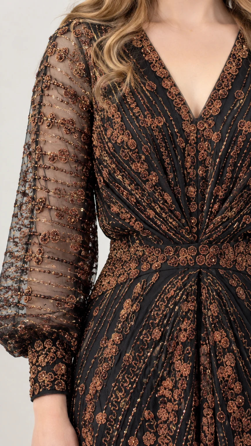 Close-up detail of sheer lantern sleeve with intricate bronze sequin pattern and button cuff