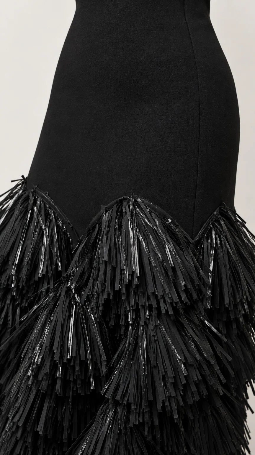 Close-up detail of textured fringe layers on black evening dress