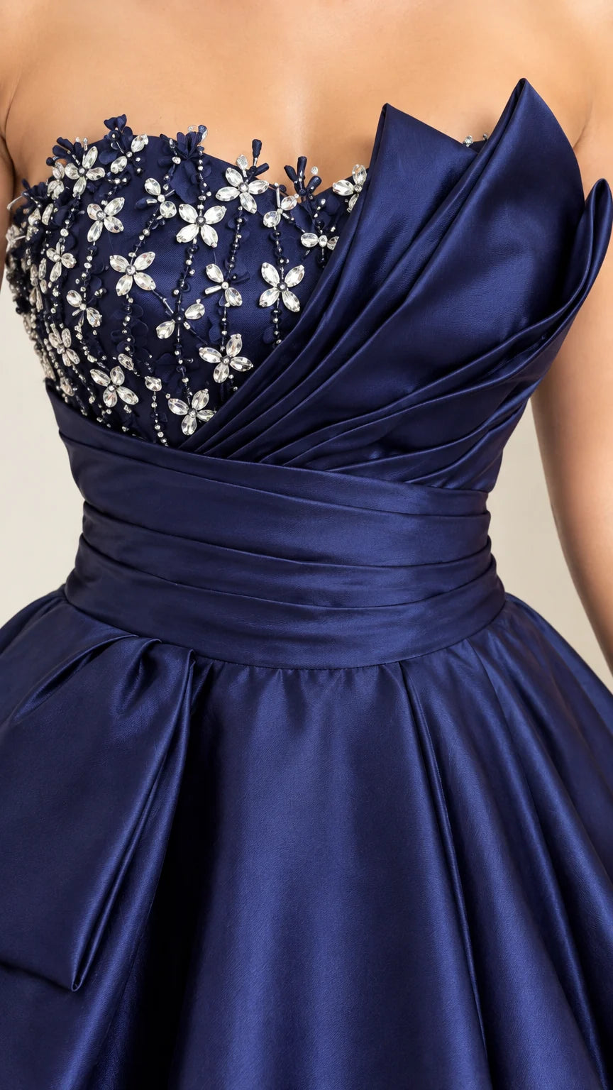 Close-up detail of navy blue bodice with floral crystal beadwork and origami pleated fold
