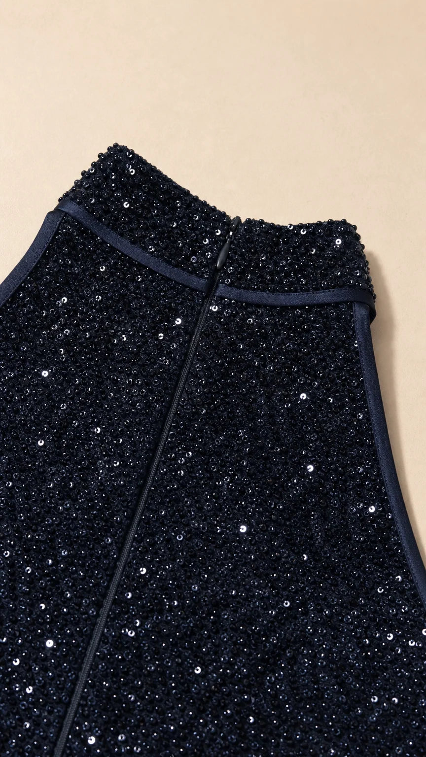 Close-up detail of navy sequin fabric and zipper construction