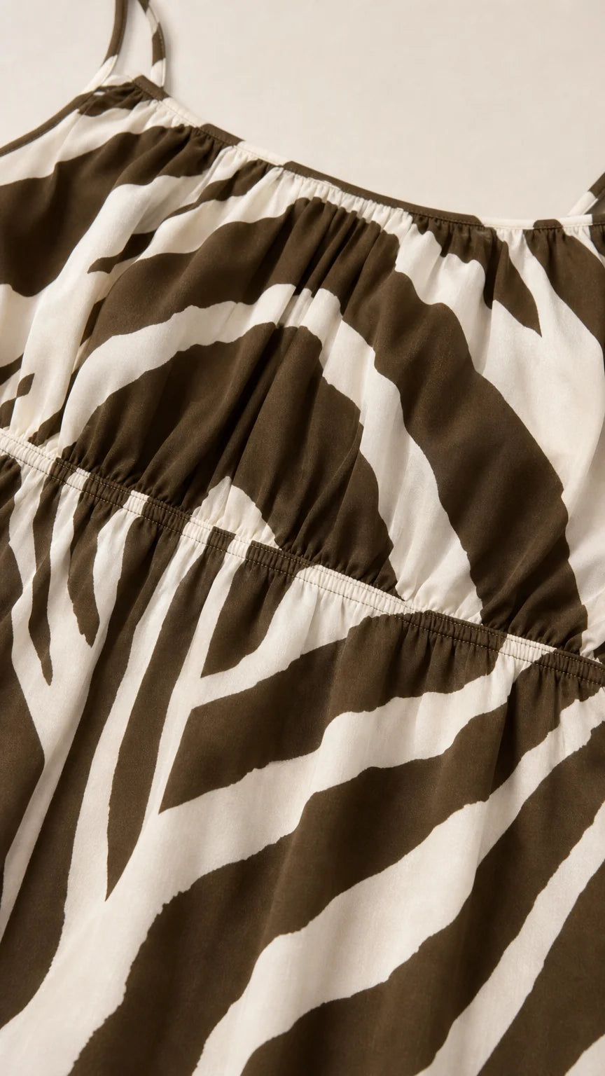 Close-up detail of smocked bodice on brown zebra print dress