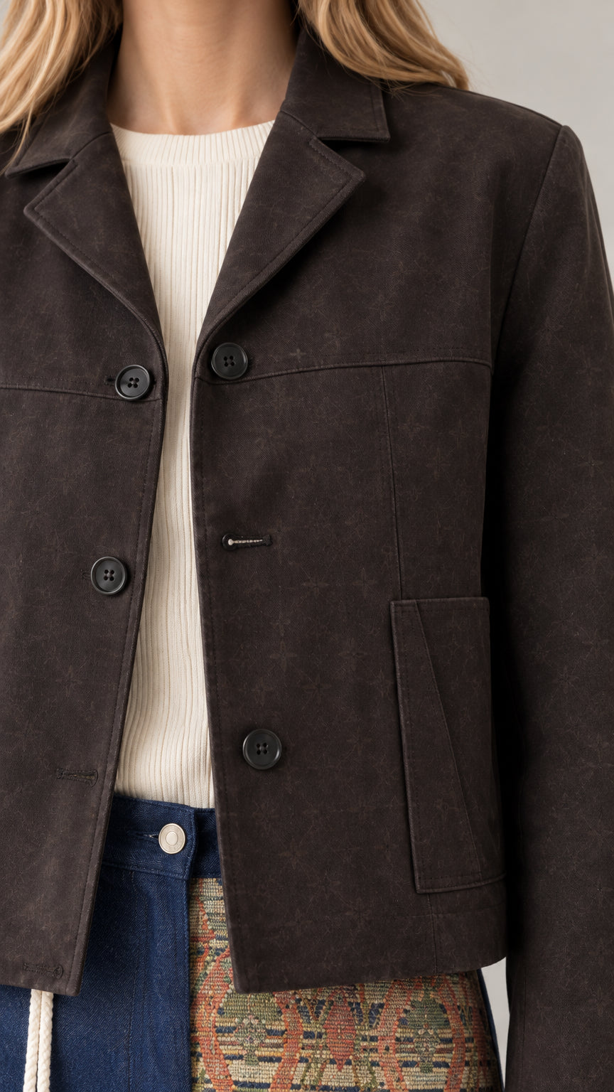 Close-up detail of espresso brown cropped jacket notch lapel and front buttons