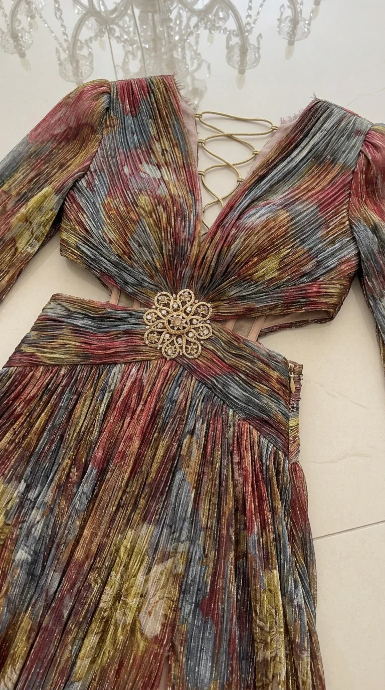 Close-up flat lay of metallic plissé bodice, ornate floral brooch, cutouts, and back ties