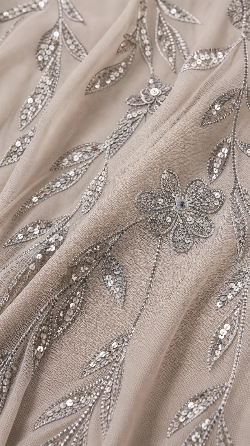 Close-up fabric detail showing intricate sequin vine and flower embroidery on mesh