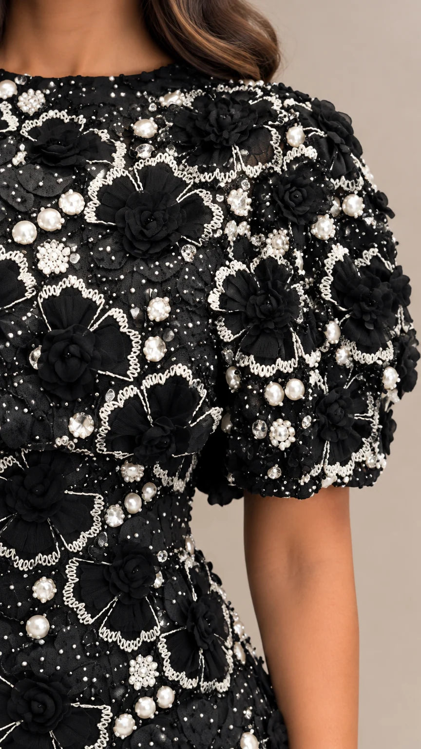 Close-up detail of 3D floral rosettes and faux pearl beadwork on bodice and sleeve