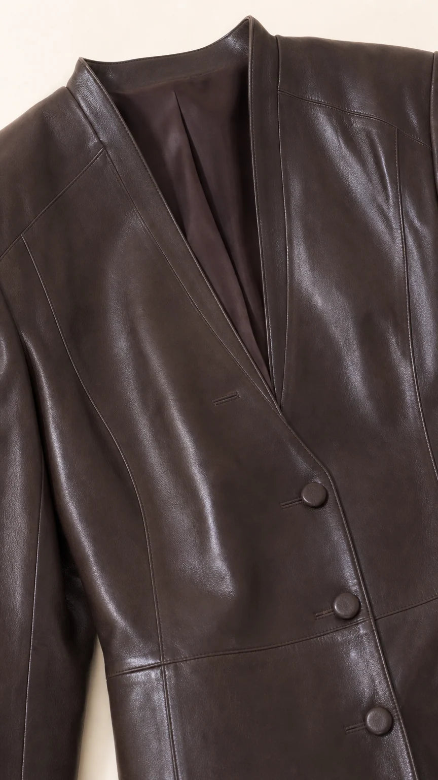Close-up detail of collarless V-neckline and button closure on Chocolate Brown faux leather blazer