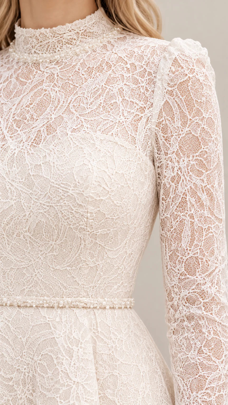 Close-up detail of floral lace fabric, mock neckline, and beaded waist trim