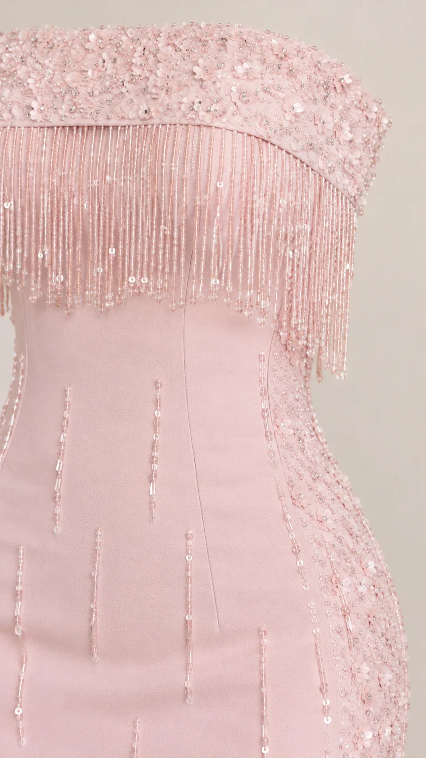 Close up of delicate beaded fringe and sequin detailing on blush pink bodice