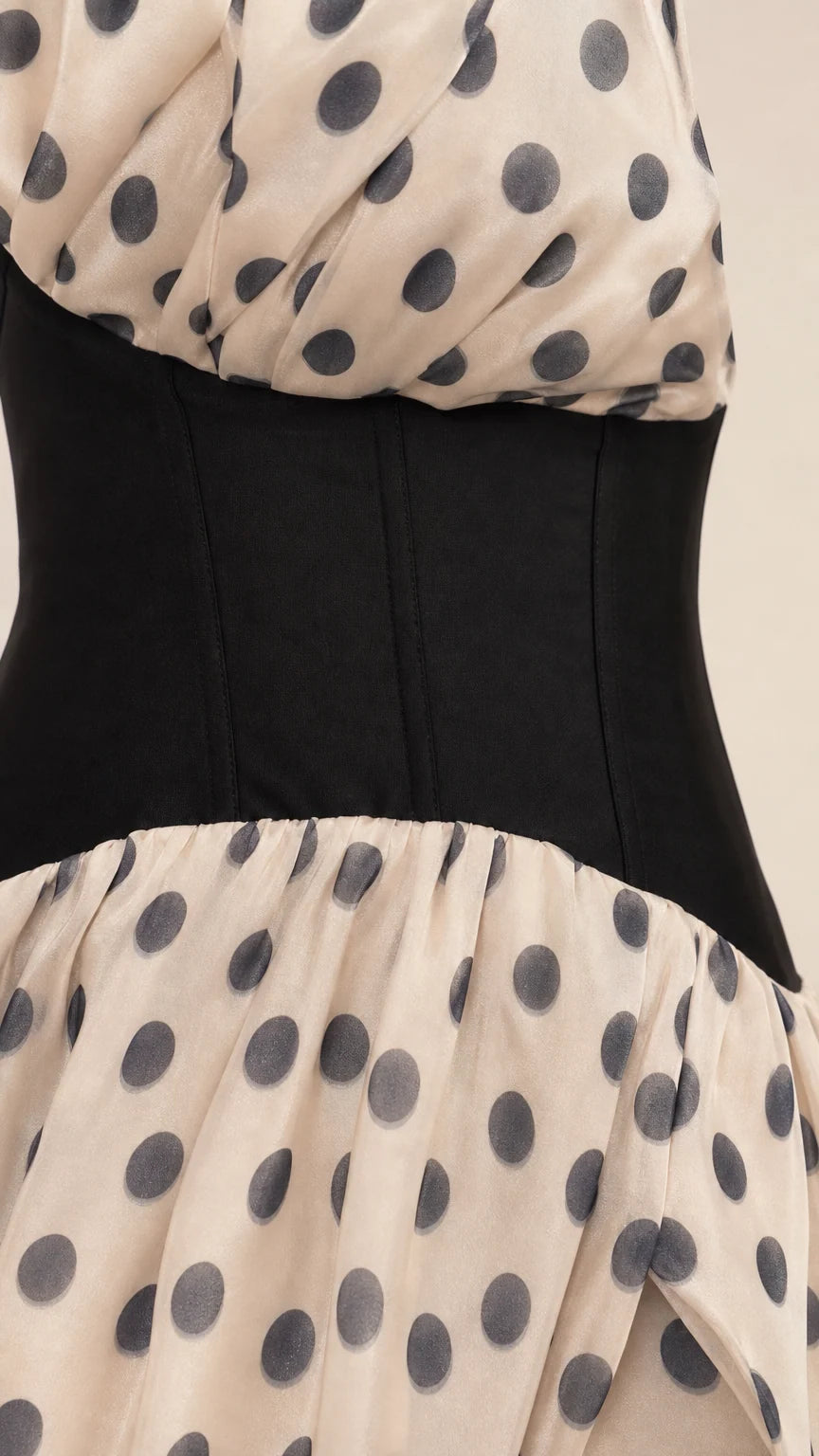 Close-up detail of black corset waist and polka dot fabric