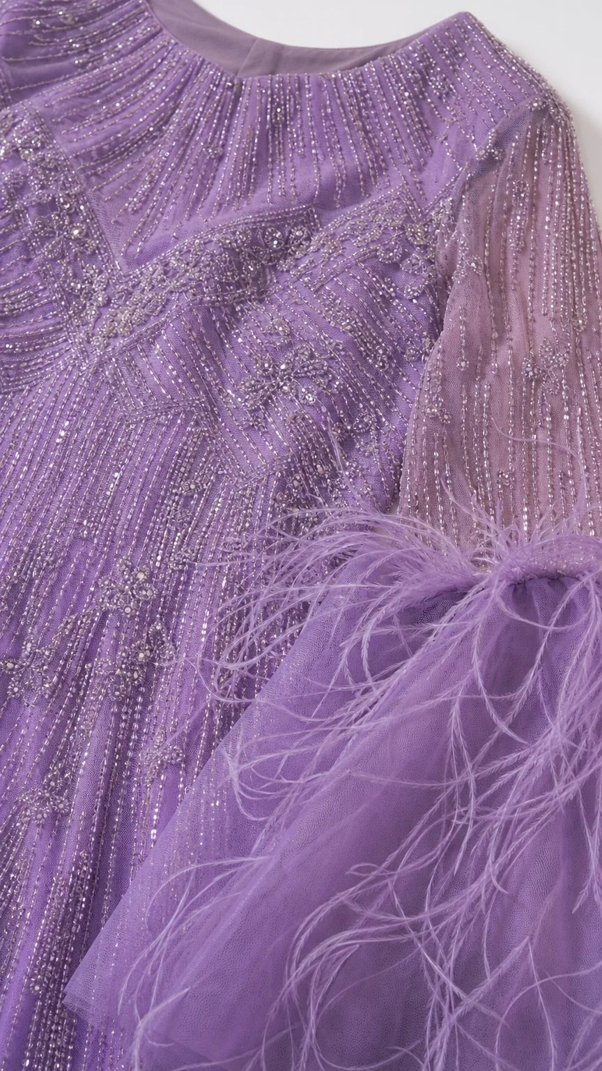 Close-up detail of lavender neckline and sleeve showing intricate beadwork and feather embellishment