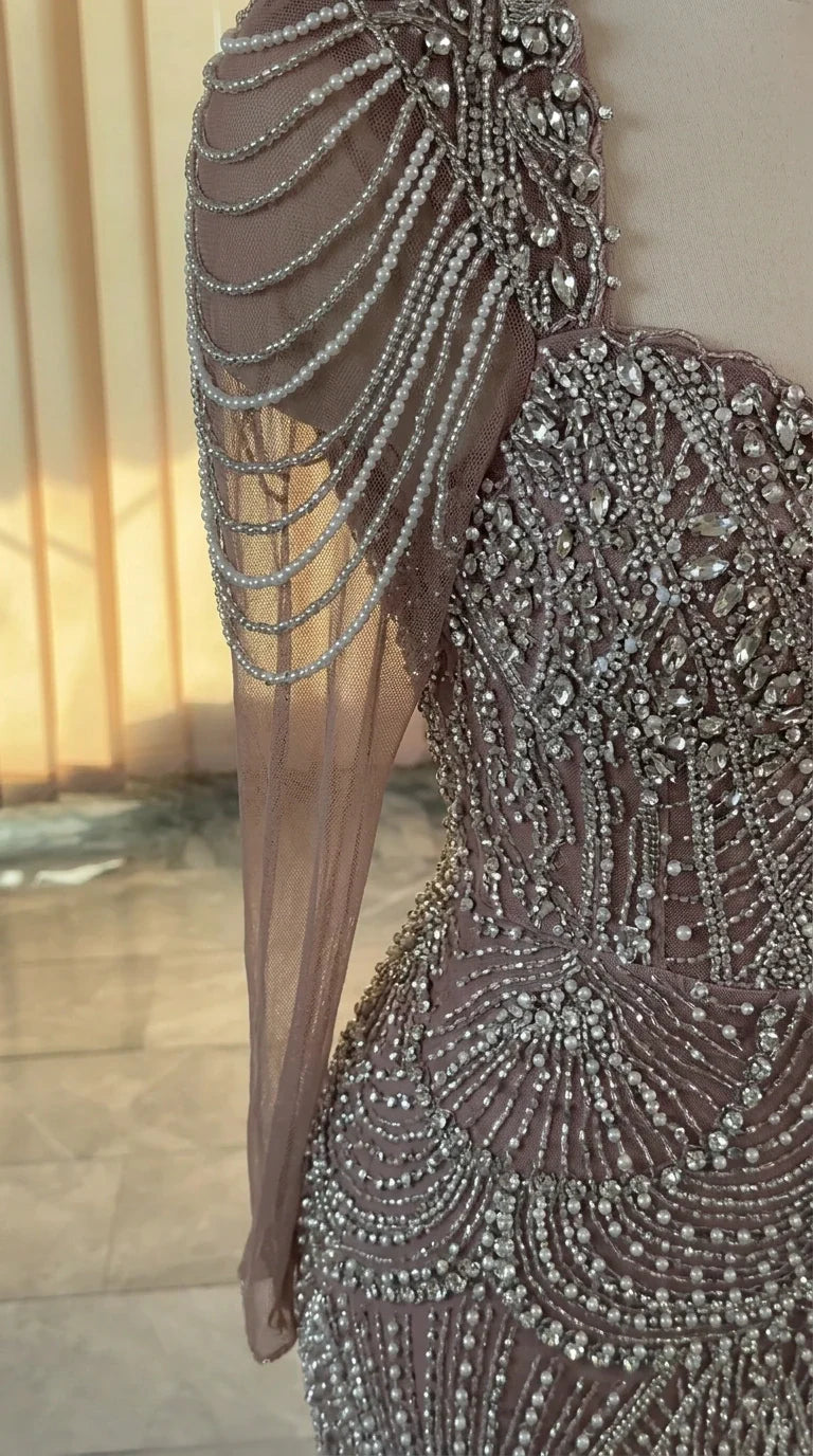 Close-up of intricate crystal beading and draped pearl shoulder sleeve detail