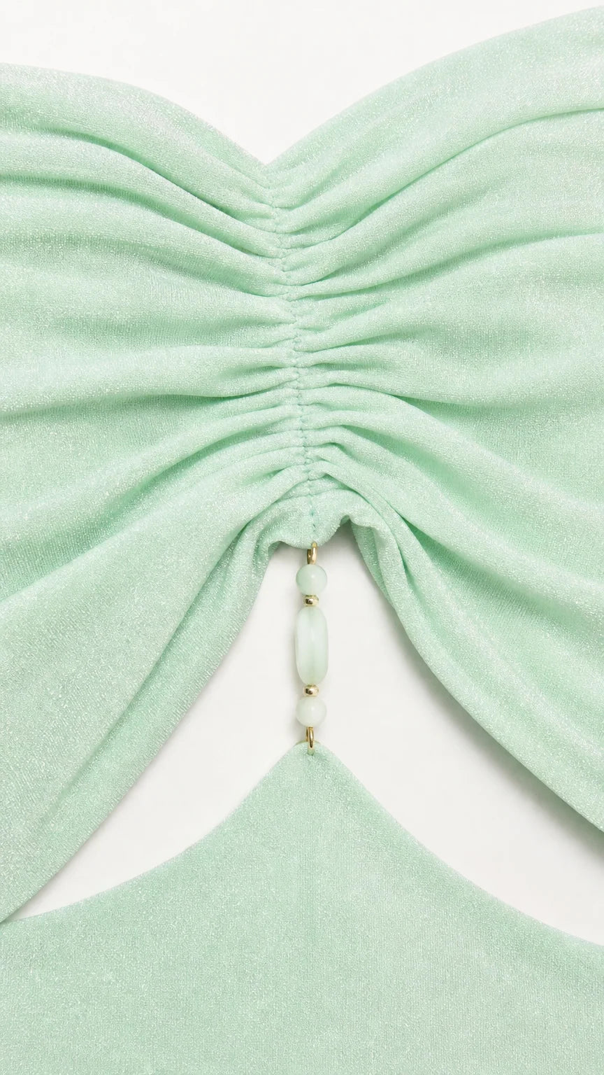 Close-up of ruched bodice and beaded detail on mint green dress