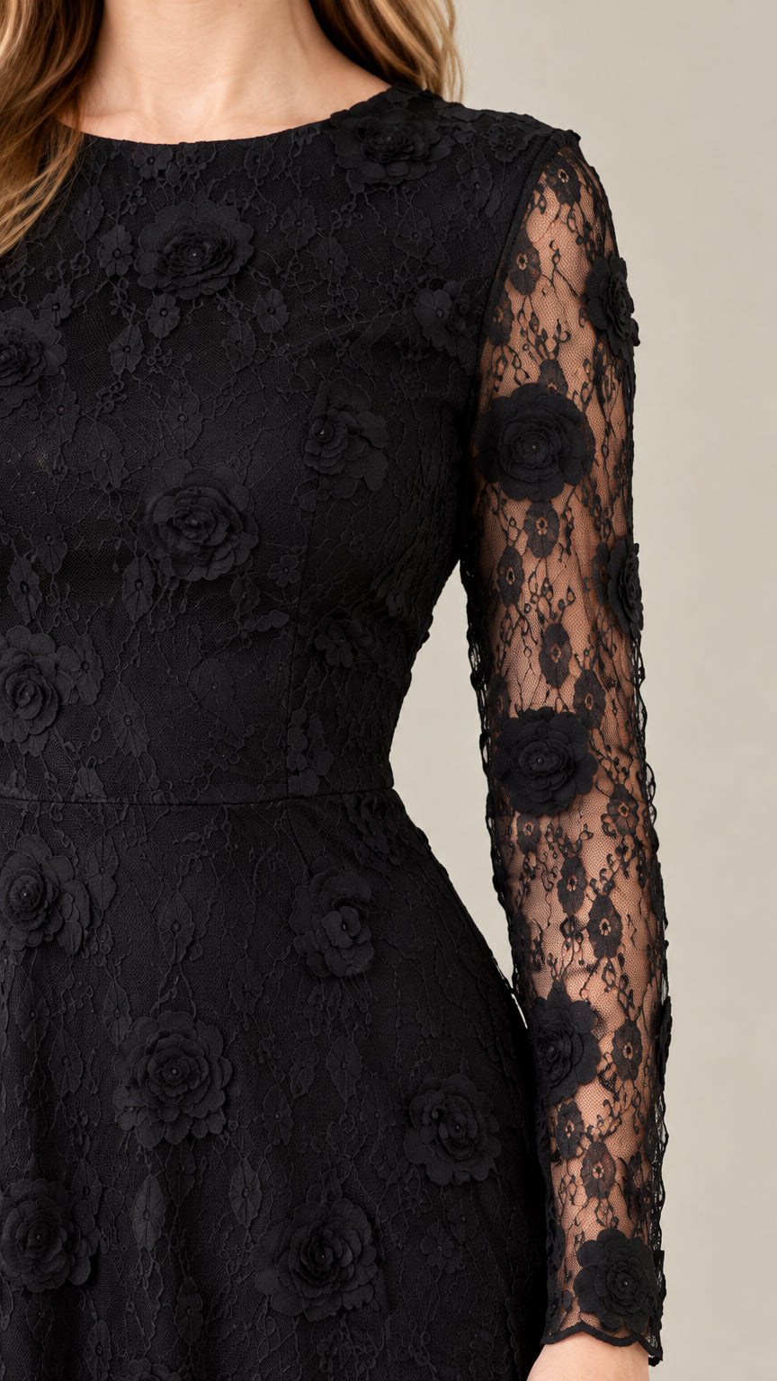 Close-up detail of textured floral lace fabric and sheer sleeve on black gown