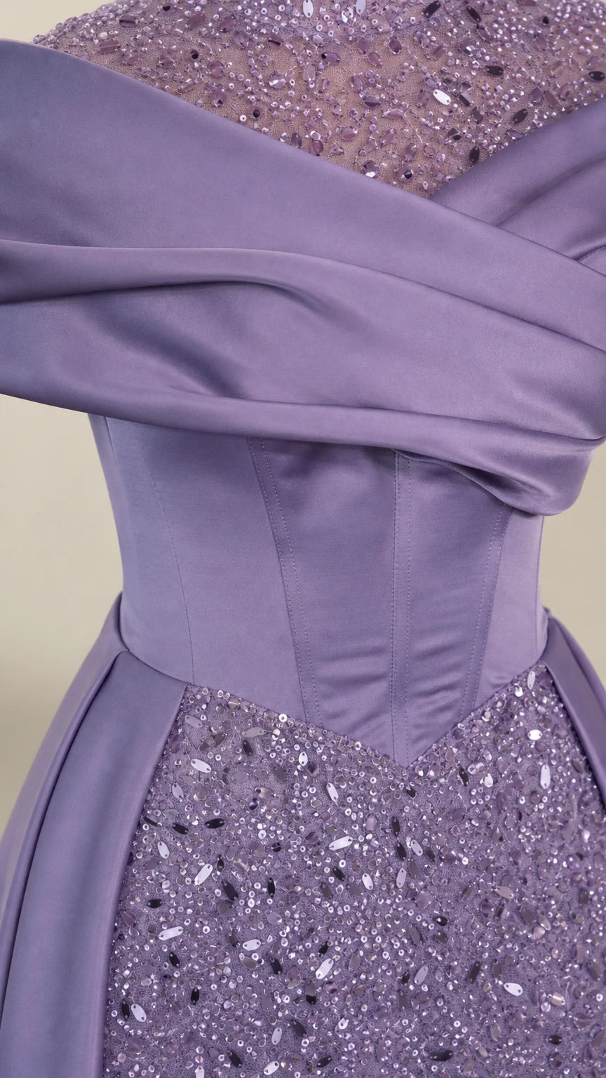 Close-up detail of lavender draped satin corset waist and shimmering sequin embellishments