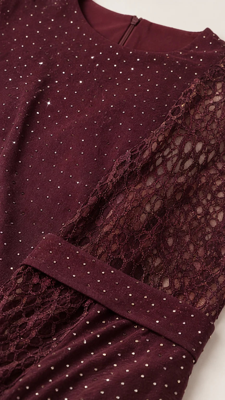 Close up of burgundy lace fabric with delicate sparkle rhinestone embellishment
