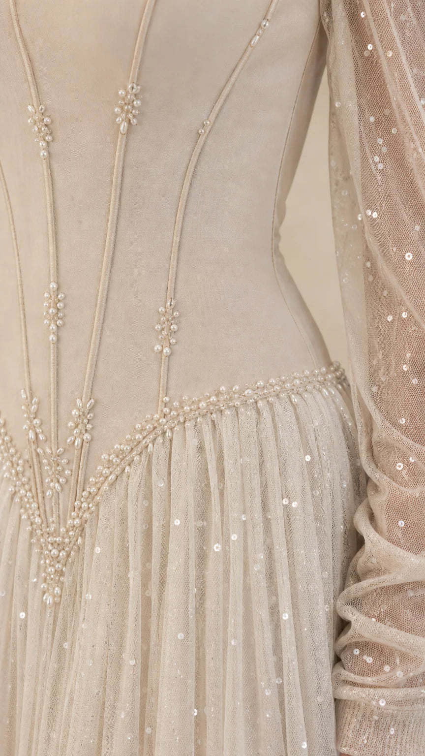 Close-up of structured corset bodice with boning lines and pearl beaded basque waist trim