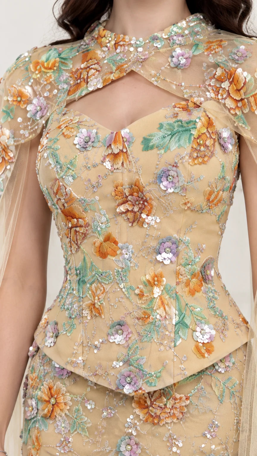 Close-up detail of floral sequin embroidery and keyhole neckline on Champagne evening dress