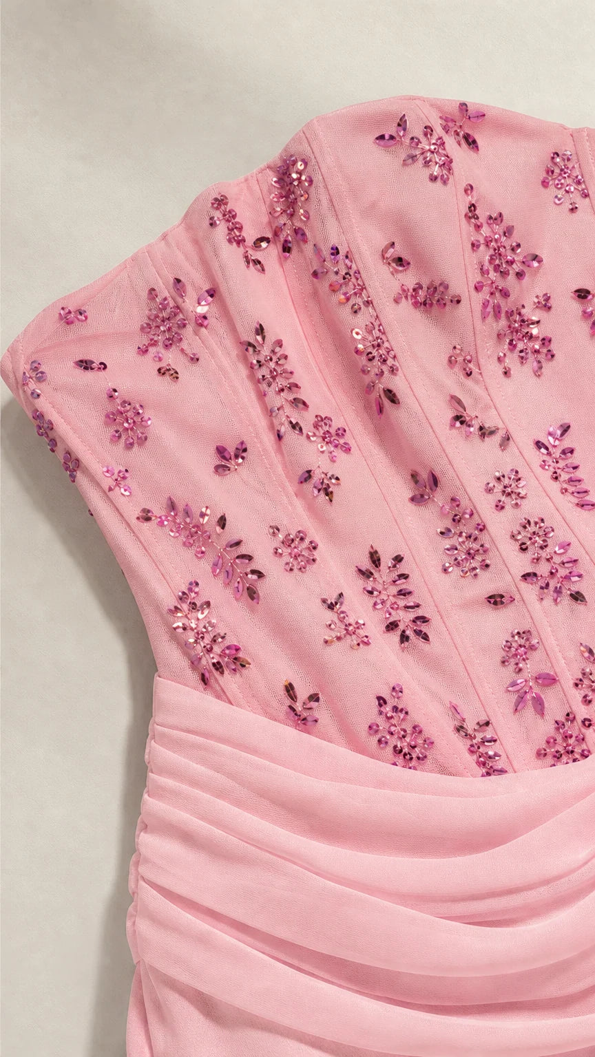 Close-up of pink beaded corset bodice with floral sequin embroidery and draped waistband