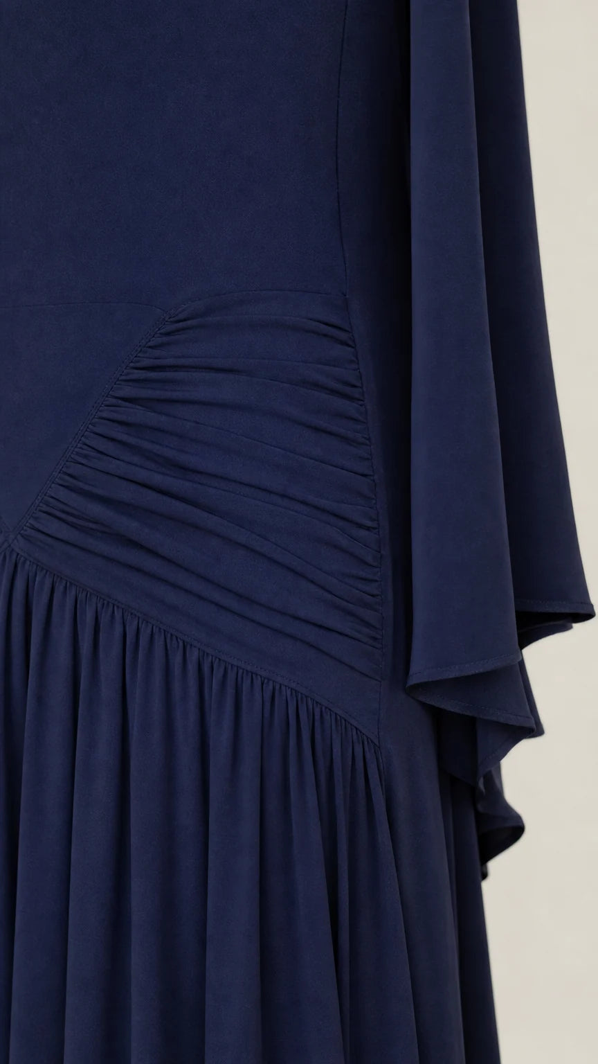 Close-up detail of ruched waist and textured fabric on navy maxi dress