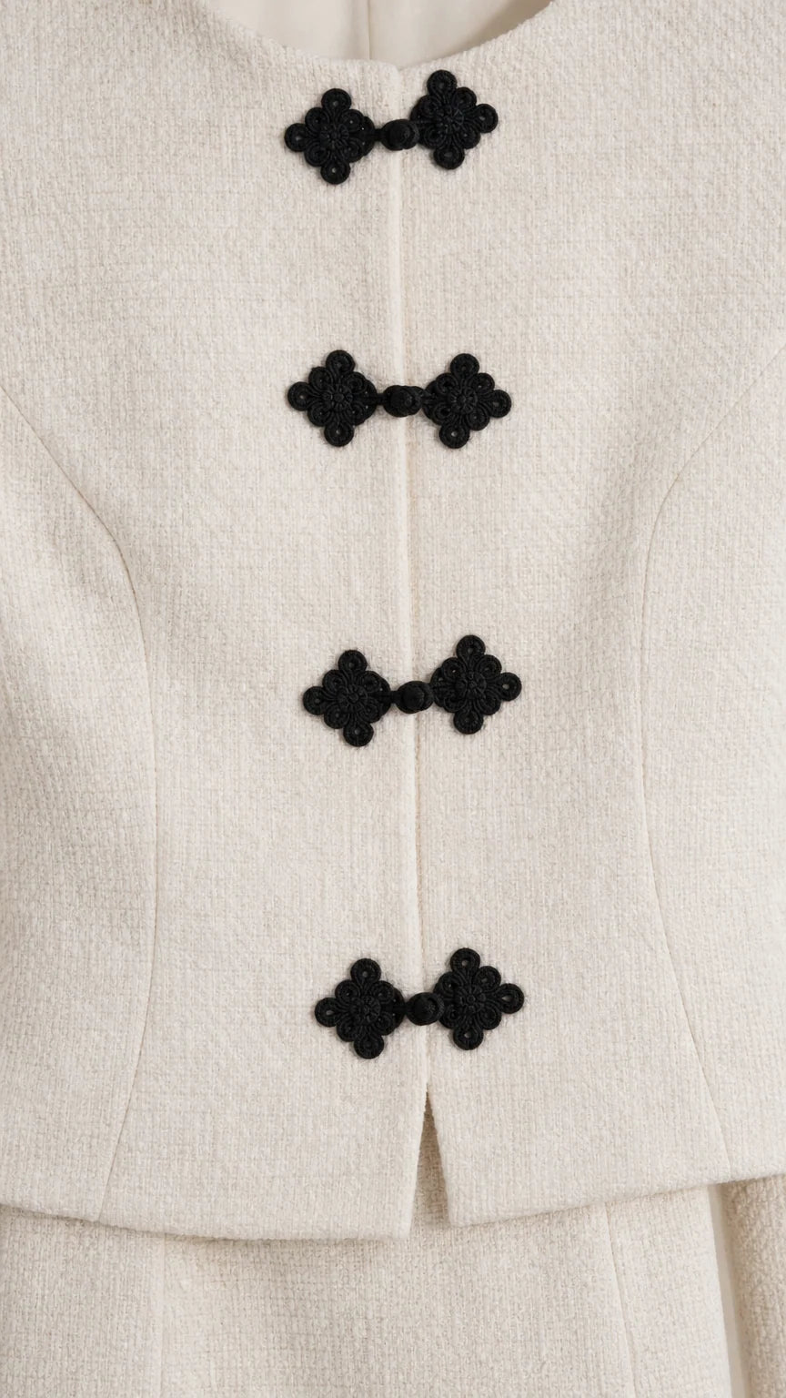Close-up detail of textured fabric and decorative black knot closures