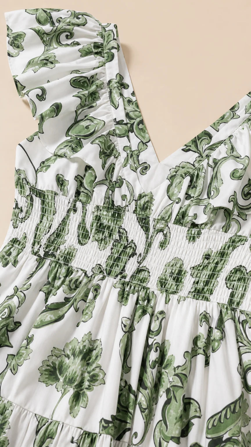 Close up of ruffle shoulder and smocked bodice detail on white floral dress