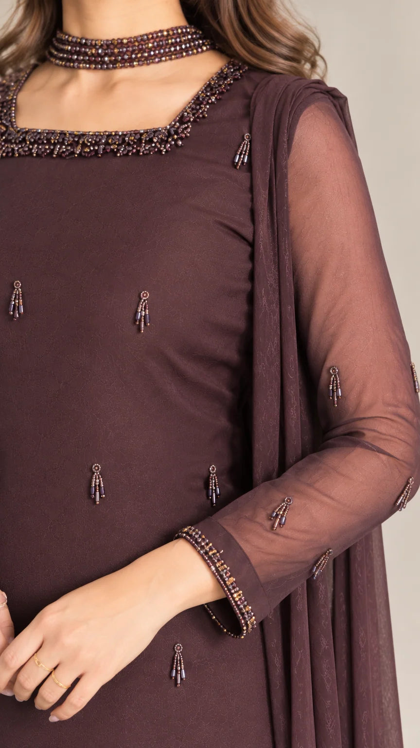 Close-up of beaded square neckline and sleeve cuffs on chocolate brown tunic