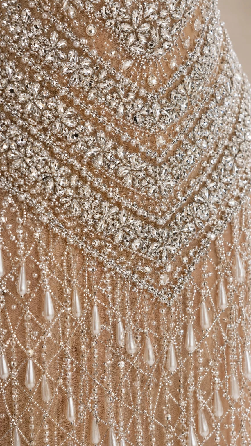 Close-up detail of rhinestone embroidery and droplet pearl beadwork
