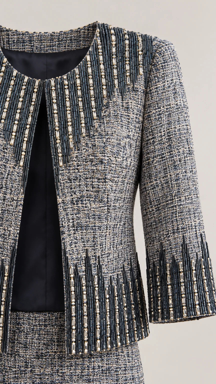 Close-up detail of woven tweed fabric, lining, and intricate beaded trim