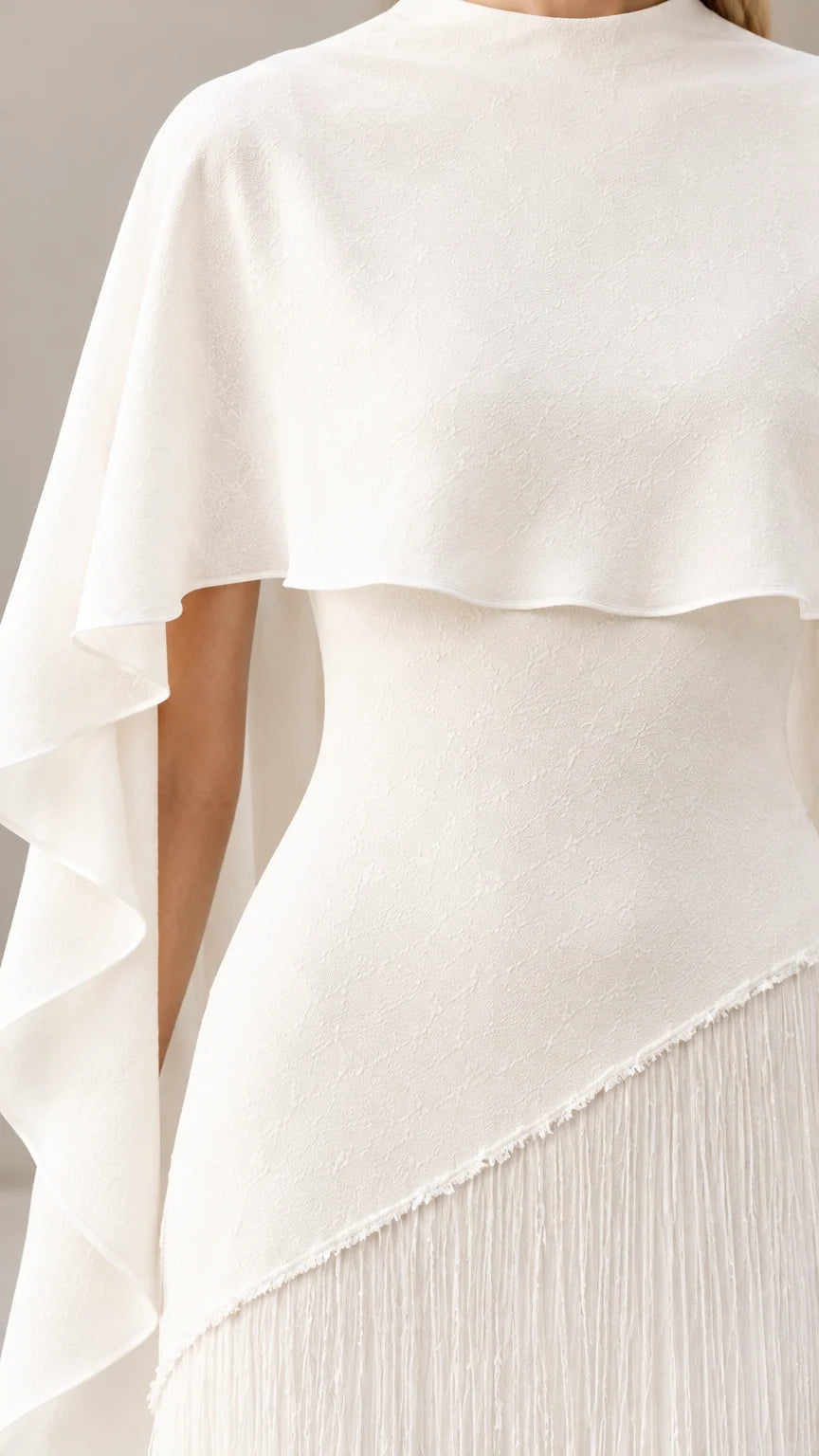 Close up of white mock neck and capelet overlay bodice detail