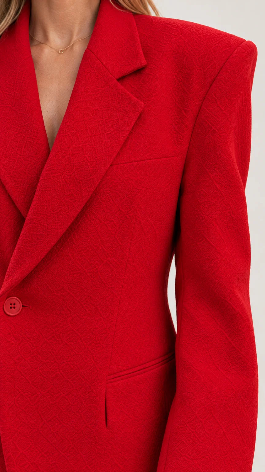 Close up of textured fabric and lapel details on red blazer dress