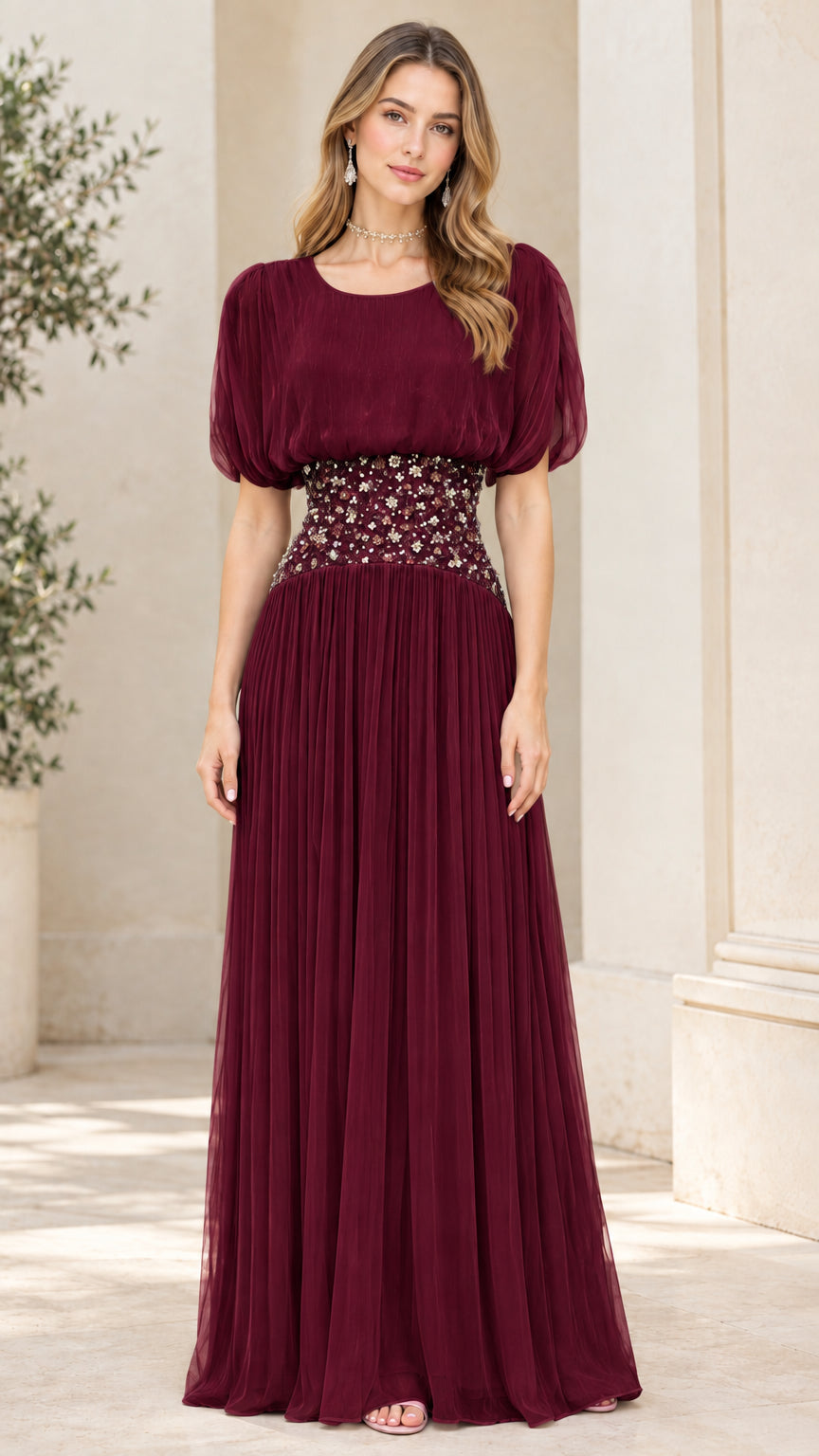 Front view of burgundy pleated evening maxi dress with embellished waistband