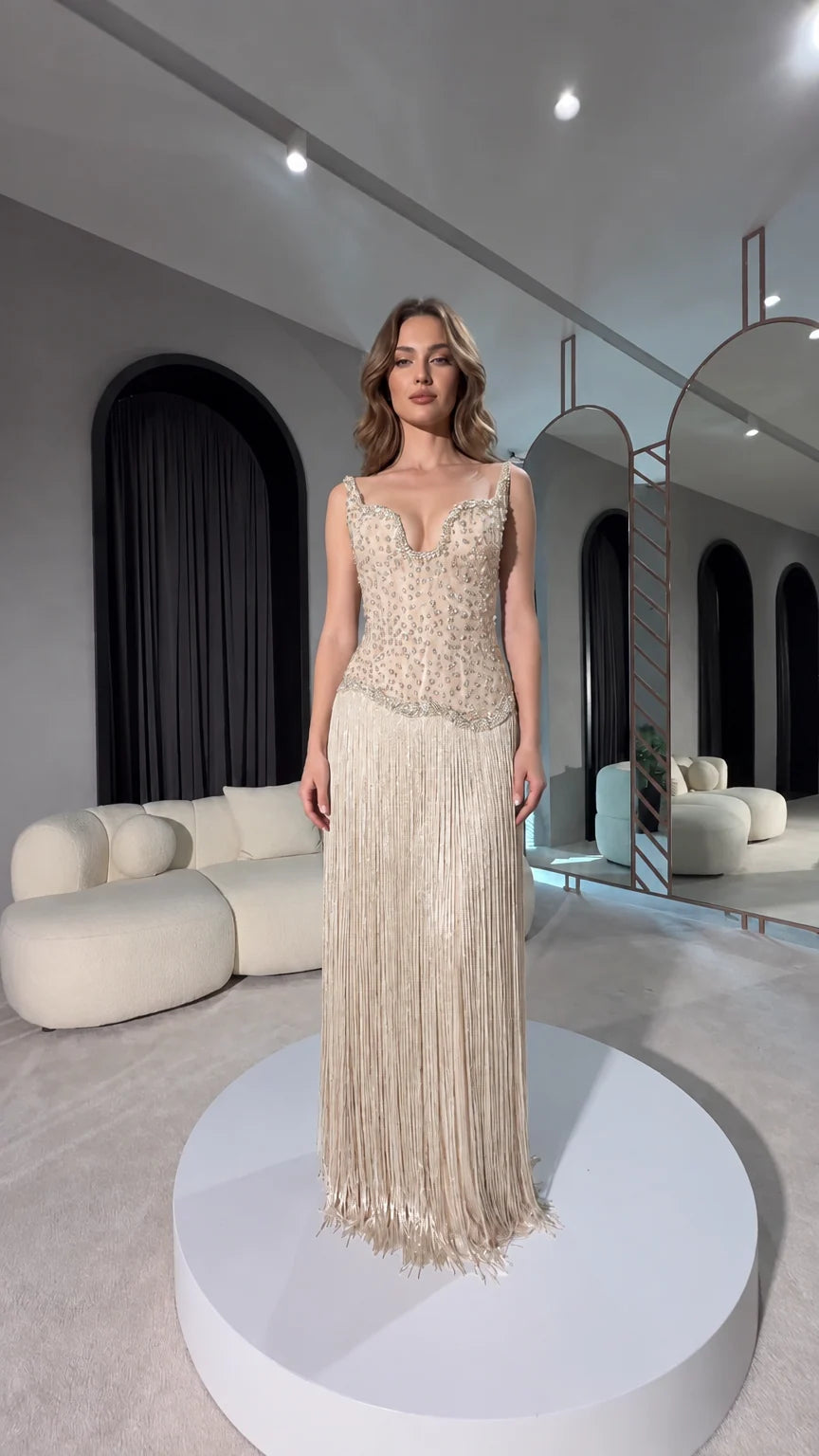 Front view of champagne gold beaded corset evening dress with long fringe